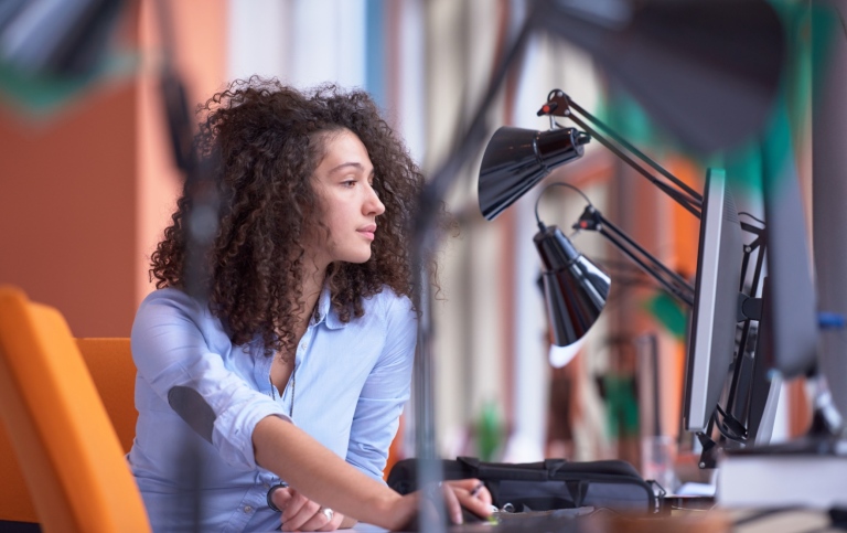 Young woman at an office desk. Photo: Mostphotos