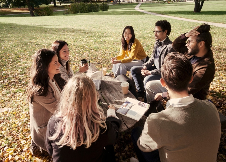 A group of students on an autumnal campus.