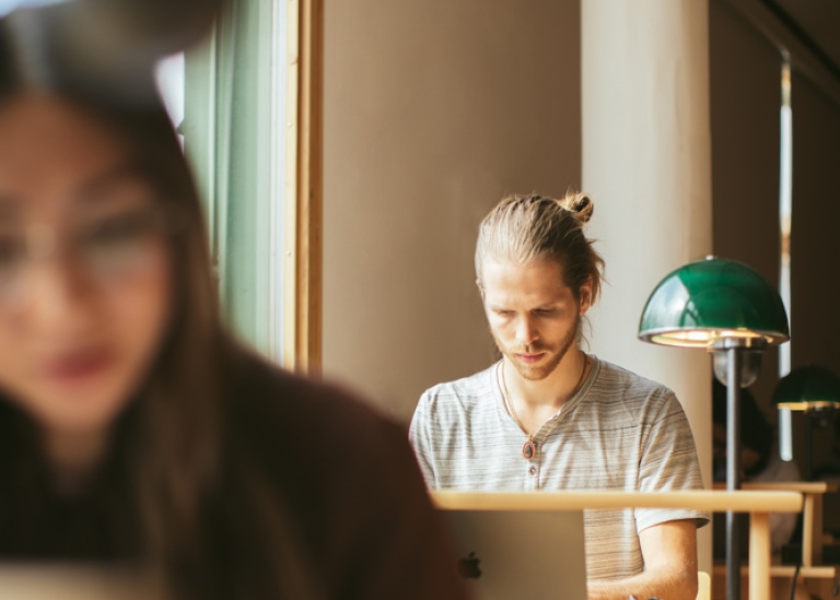 Kvinnlig student läser i biblioteket