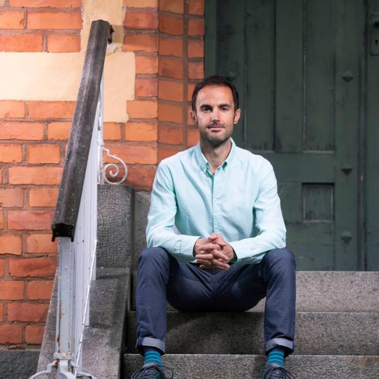 Andrea Lucarelli sitting on a flight of stairs.