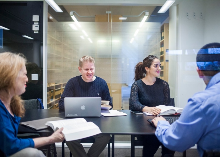 A group of students in a group room at the library.