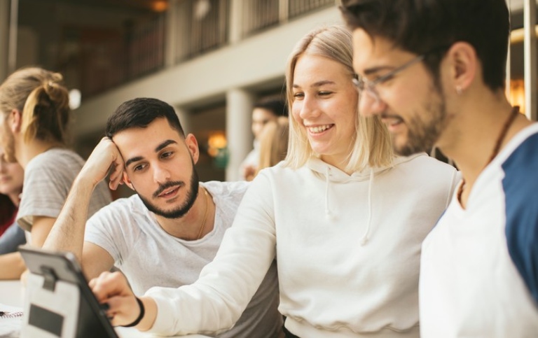 Three students looking at a tablet. Photo: Niklas Björling